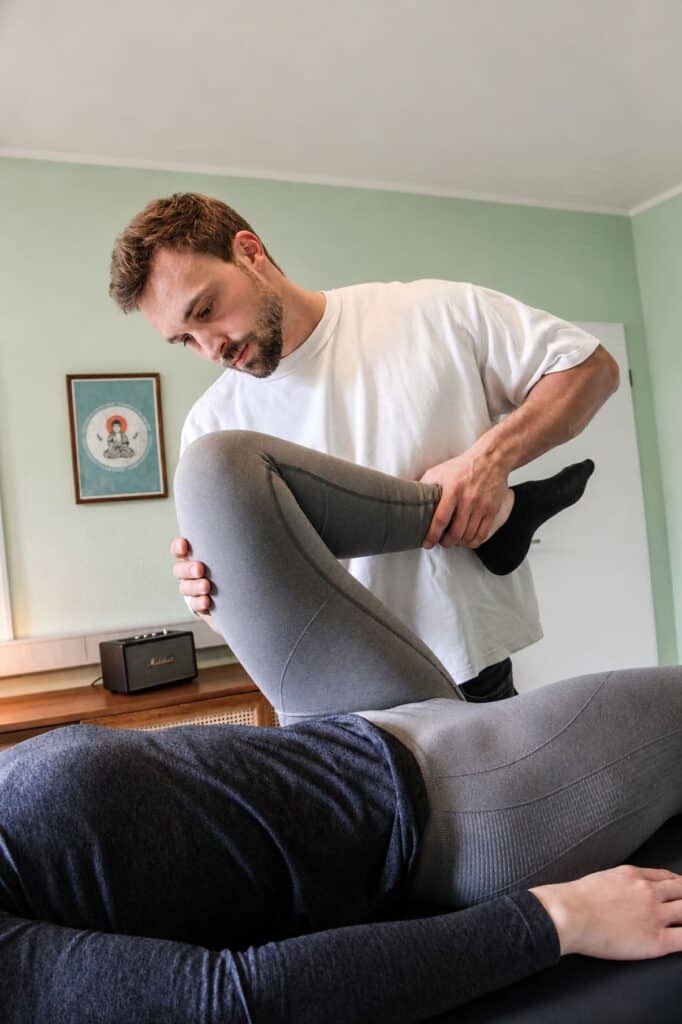 Physiotherapeut behandelt Hüftschmerzen bei Patient in Praxis, gezielte Therapie.