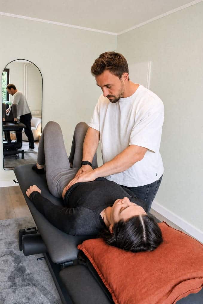 Therapeut bei Physiotherapie, Behandlung einer Patientin im Behandlungsraum.